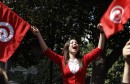 A protester waves flags and shout slogans, during a demonstration in Tunis